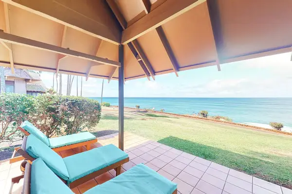 Island vacation home exterior features tropical landscaping and sunny surroundings