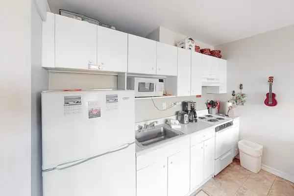 Spacious kitchen showcases refrigerator microwave oven and generous counter space