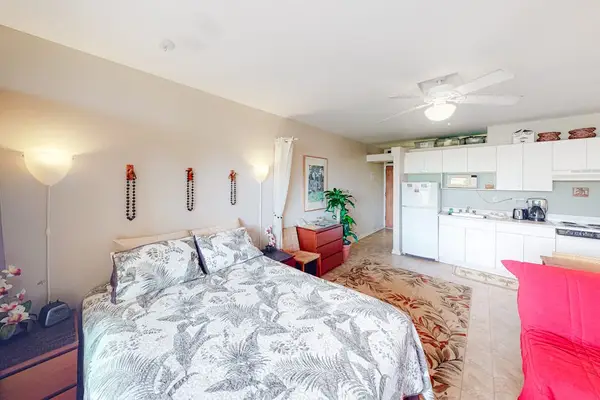 Comfortable studio sleeping area opens toward bright kitchen dining space