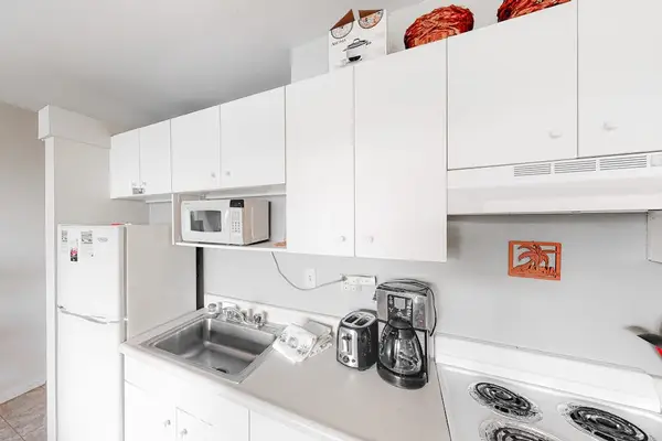 Bright kitchen features appliances countertops and convenient meal preparation space