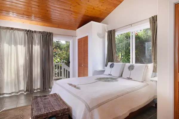 Breezy Guest Bedroom with Direct Deck Access & Slanted Wood Ceiling