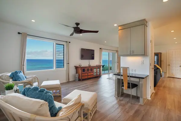 Ocean-view living room with comfortable seating and ceiling fan