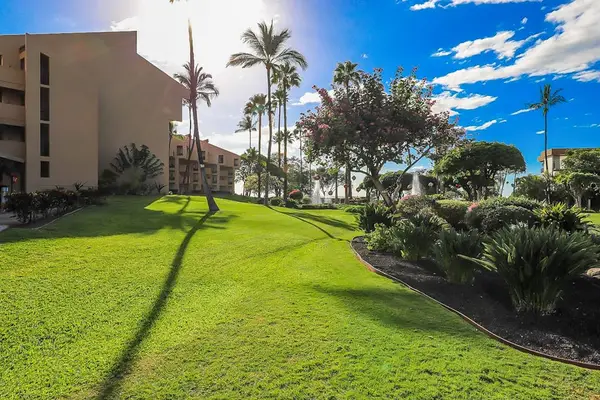 Lush green lawn and tropical landscaping create a warm setting to enjoy the fresh island air
