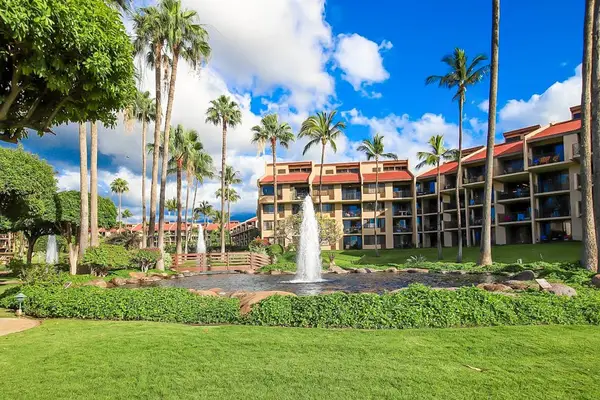 Beautiful resort courtyard with a charming fountain surrounded by lush greenery and tropical palms