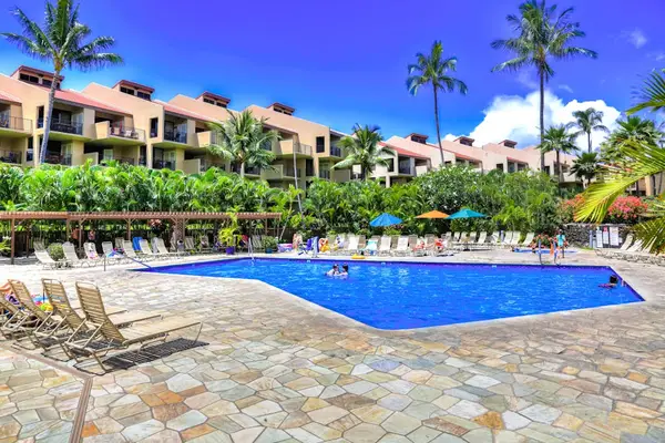 Resort pool surrounded by swaying palms and tropical scenery