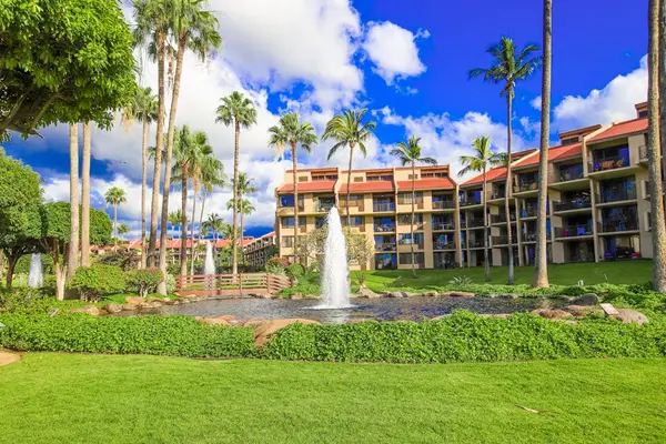 Spacious resort grounds framed by palms and blue skies