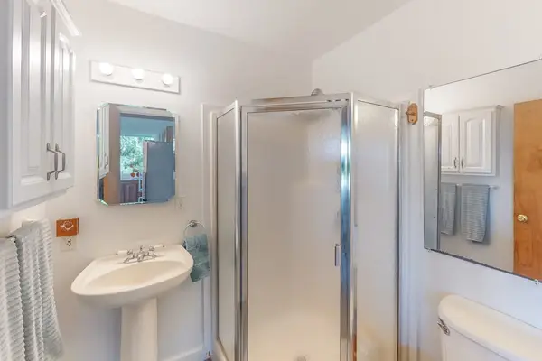 Bright Guest Bathroom featuring Pedestal Sink & Walk-In Glass Shower