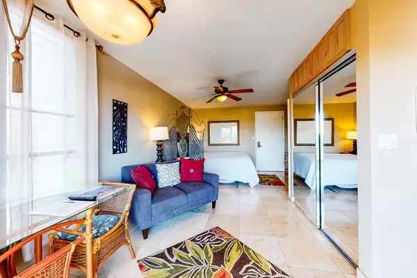 Overview of Studio Suite showing Living Seating, Mirrored Closet, and Bed