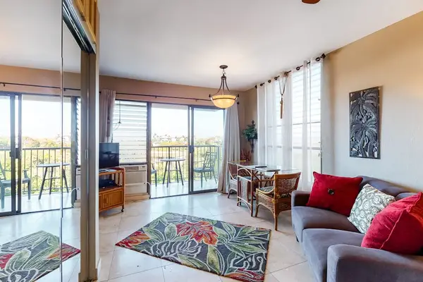 Open Studio Layout with Comfortable Sofa, Dining Corner, and Balcony Access