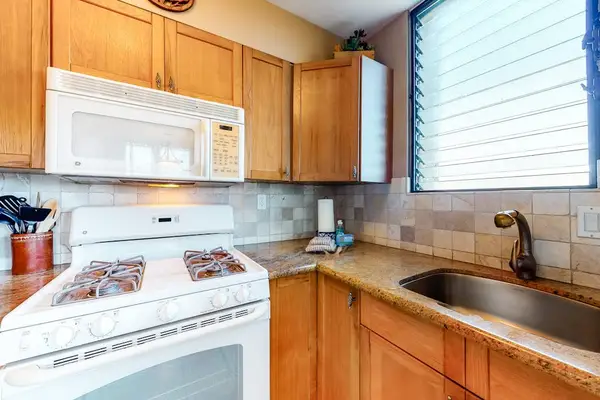 Fully Equipped Kitchen with Gas Stove, Overhead Microwave, and Tile Backsplash