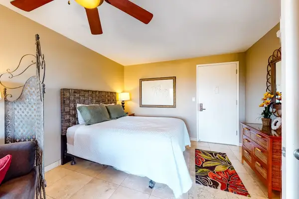 Bedroom with Plush Bed, Ceiling Fan, and Front Entry Access