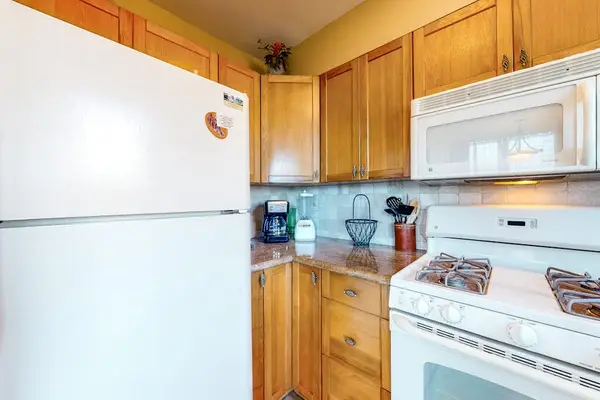 Bright Kitchen Corner featuring Refrigerator and Wood Cabinets