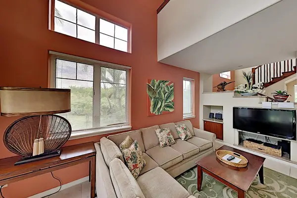 Living room with flat screen tv, high ceilings and plenty of natural light.