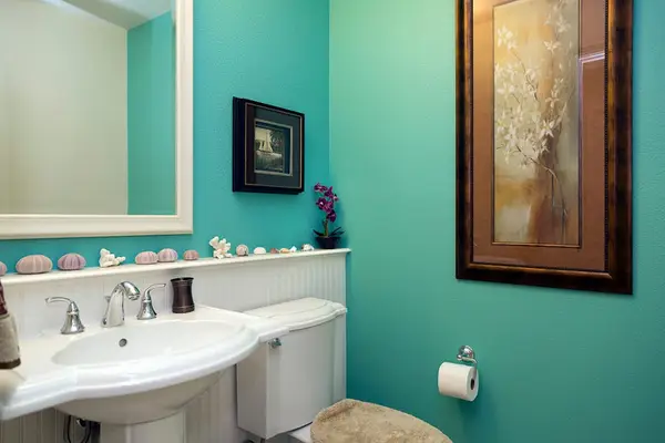 Vibrant Coastal Powder Room with Teal Accent Walls & Pedestal Sink