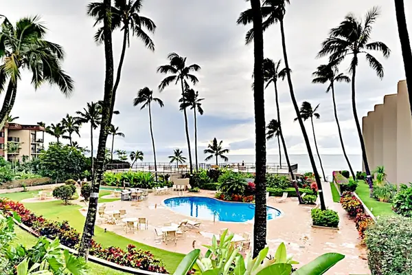 Resort pool overlooks turquoise water, sandy beaches, and tropical gardens