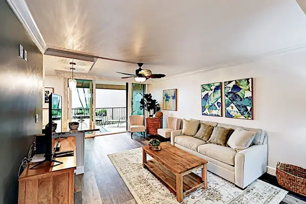 Bright living room combines comfortable seating, artwork, and kitchen access