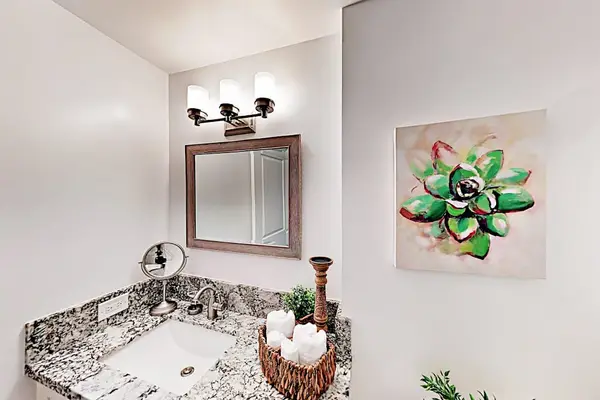 Fresh bathroom includes a vanity, mirror, tiled shower, and storage