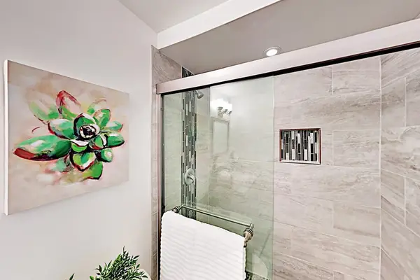 Modern bathroom combines stone tilework, contemporary fixtures, and polished surfaces