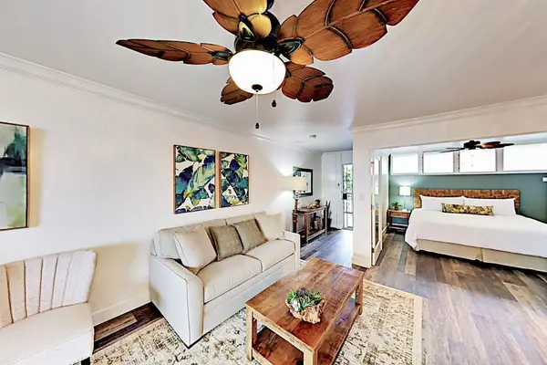 Coastal living room presents inviting seating beneath ceiling fans and windows