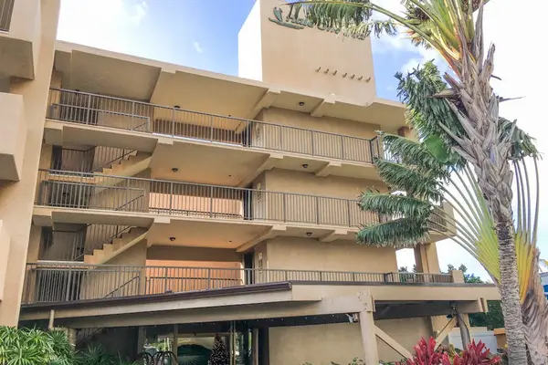 Multi-story building exterior features balconies and greenery