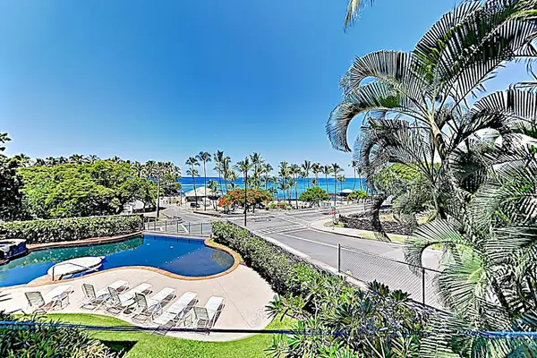 Elevated Balcony View Overlooking the Resort Pool Deck, Ocean, and Lush Palms