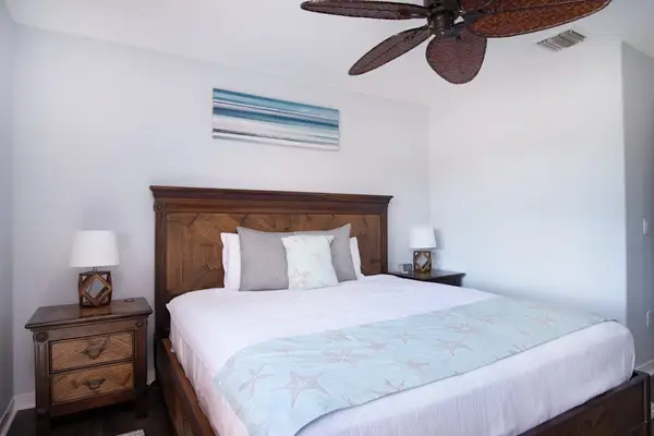 Guest bedroom with king bed and a ceiling fan for complete comfort.