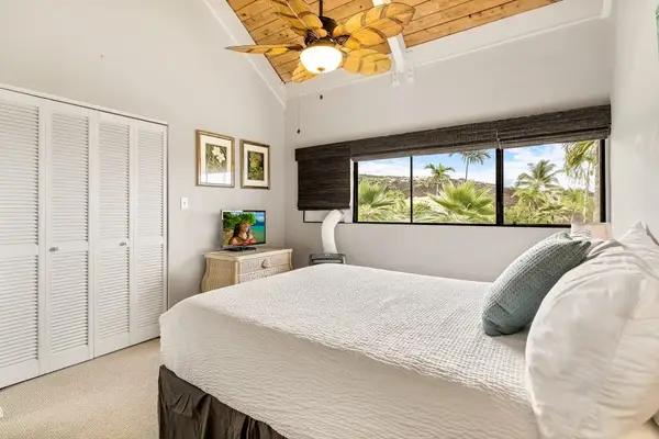 A comfortable bedroom layout featuring a large closet, dresser storage, and scenic window views