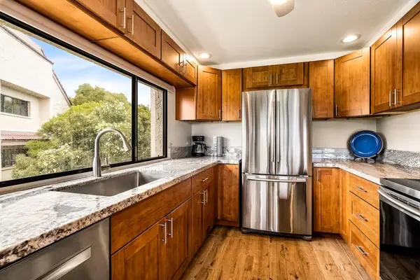 A bright kitchen workspace featuring a deep sink situated right under a large window with outdoor views