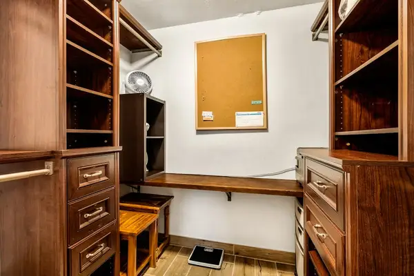 An expansive walk-in closet featuring extensive built-in shelving, drawers, and hanging space