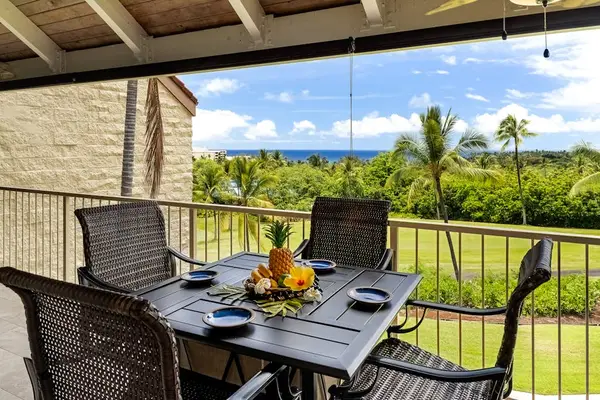 An outdoor dining area perfectly positioned to enjoy fresh air, lush greenery, and a glimpse of the ocean