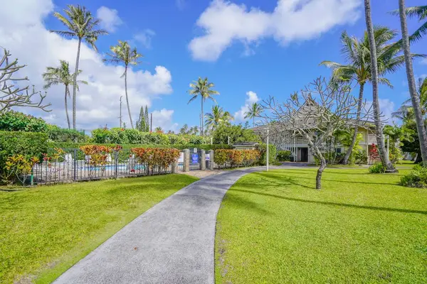 Paved walking path through lush tropical property grounds