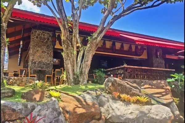 Resort entrance showcases stone architecture, tropical gardens, and welcoming pathways