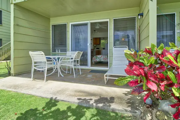 Private lanai with outdoor seating overlooking beautifully landscaped grounds.