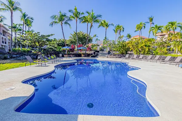 Crystal-Clear Resort Swimming Pool Surrounded by Sun Loungers & Palms