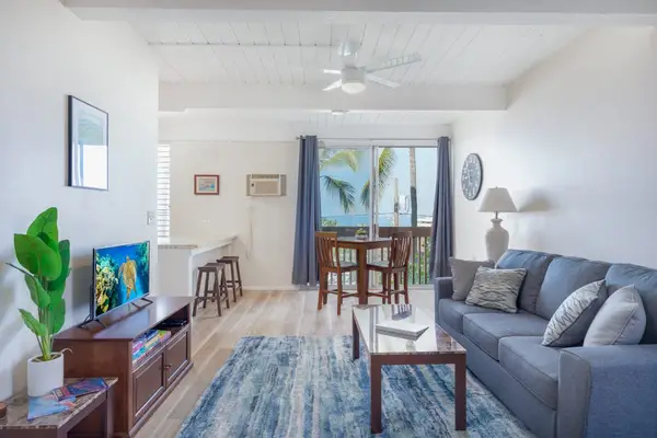 Blue Sectional Sofa, TV Console, Area Rug & Sliding Glass Balcony Access