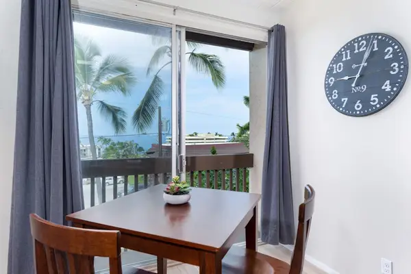 Wooden Table Seating, Wall Clock & Sliding Glass Balcony Access