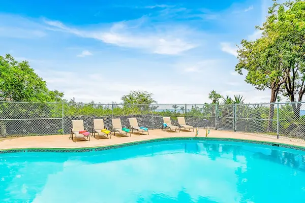 Sunlit Outdoor Swimming Pool with Poolside Lounge Chairs and Scenic Views