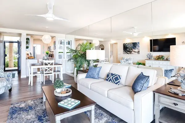 Bright living room with sliding glass doors, abundant natural light, and a comfortable sofa bed for extra guests.