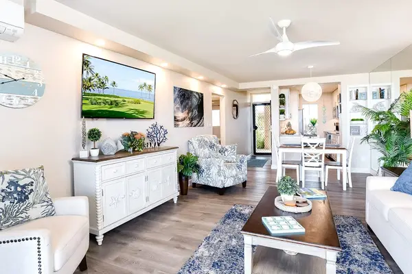 Bright living room with sliding glass doors, abundant natural light, flat screen tv and a comfortable sofa bed for extra guests.