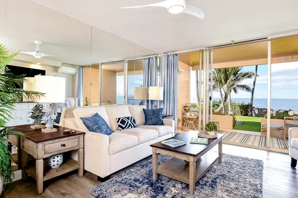 Bright living room with sliding glass doors, abundant natural light, and a comfortable sofa bed for extra guests.