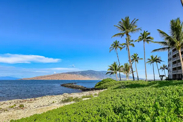 Crystal-clear turquoise waters gently wash onto pristine white sandy beaches.