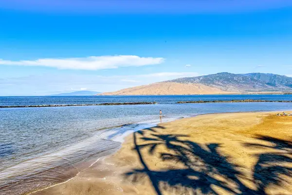Crystal-clear turquoise waters gently wash onto pristine white sandy beaches.