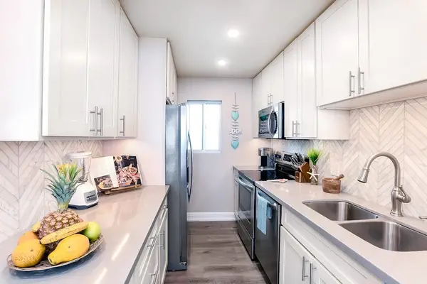 Modern stainless steel kitchen with an open-concept design that flows seamlessly into the living room, making it easy to cook, gather, and stay connected.