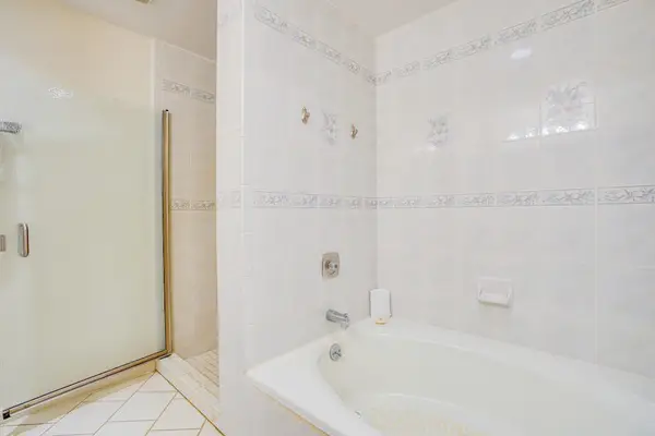 Bright Bathroom featuring Separate Soaking Tub & Glass Enclosed Shower