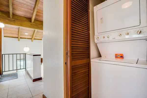 In-Unit Stacked Washer and Dryer Setup near Upper Level Landing