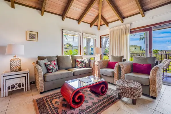 Sunlit Living Room featuring Vaulted Beamed Ceilings & Wicker Seating