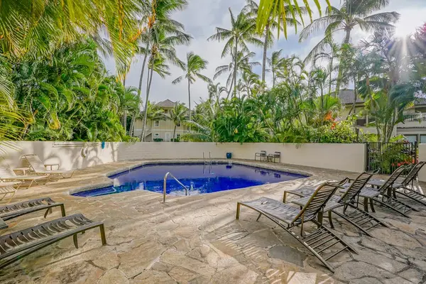 Sunlit Pool Deck featuring Comfortable Lounge Chairs & Lush Landscaping
