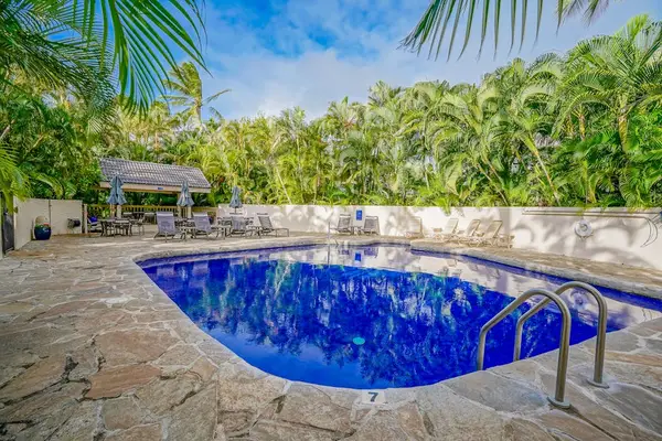 Sparkling Community Pool Enclosed by Tropical Palms & Stone Deck