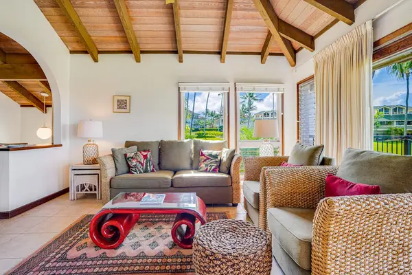Bright Living Area with Plush Wicker Armchairs & Red Accent Coffee Table