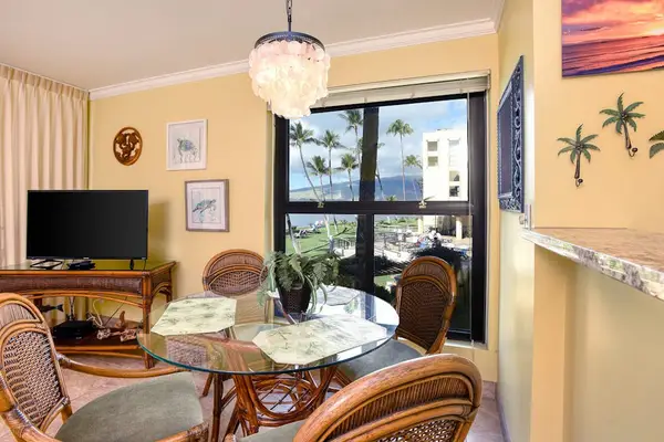 Dining area with a glass-topped table and rattan chairs